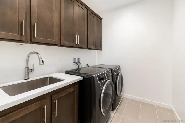 a utility room with sink dryer and washer