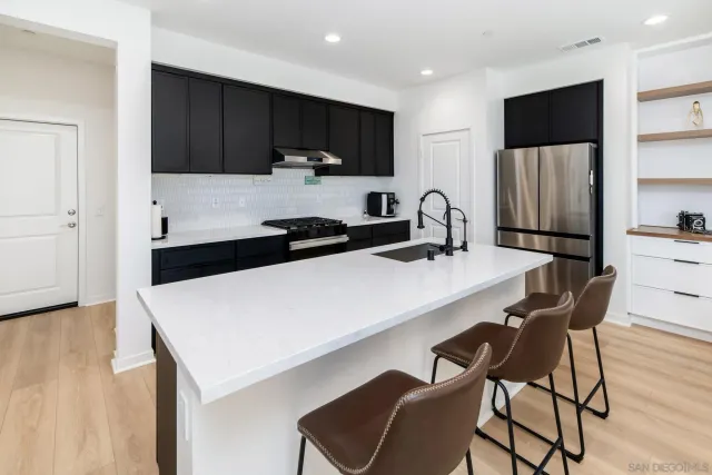 a kitchen with a sink a microwave and cabinets