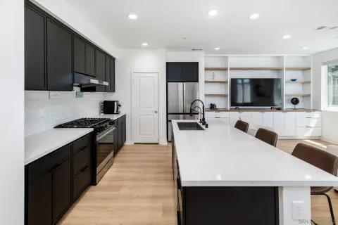 a large kitchen with stainless steel appliances a stove a sink a microwave and a refrigerator