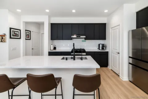 a kitchen with kitchen island a appliances a sink and a refrigerator