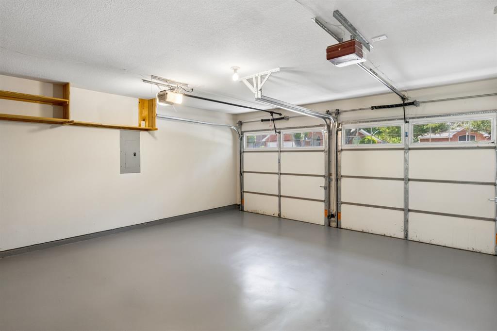 2925 Sunset Ridge McKinney, TX 75072 - Photo 31 of 33 Spacious oversized garage featuring durable epoxy flooring, built-in storage shelving, and ample room for vehicles, golf carts, hobbies, or additional storage needs.