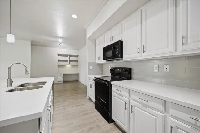 a kitchen with appliances a sink and cabinets