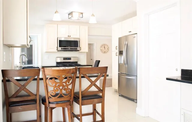 a kitchen with stainless steel appliances a refrigerator and a stove top oven
