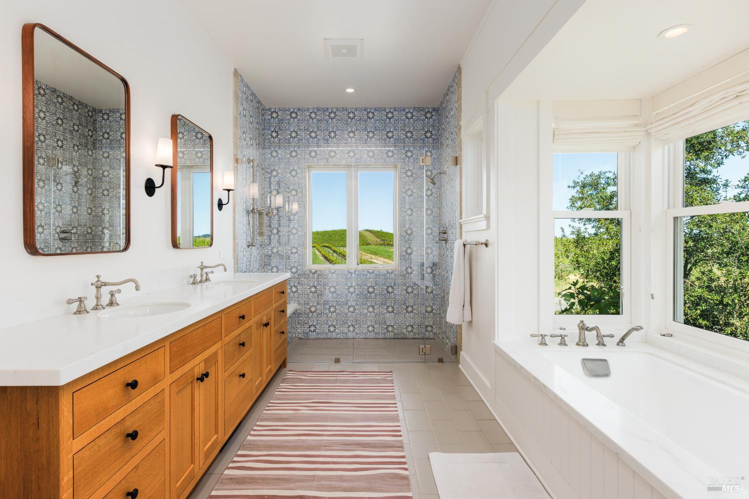 5561 Sonoma Mountain Road Santa Rosa, CA 95404 - Photo 22 of 70 a bathroom with a double vanity sink large mirror and a bathtub