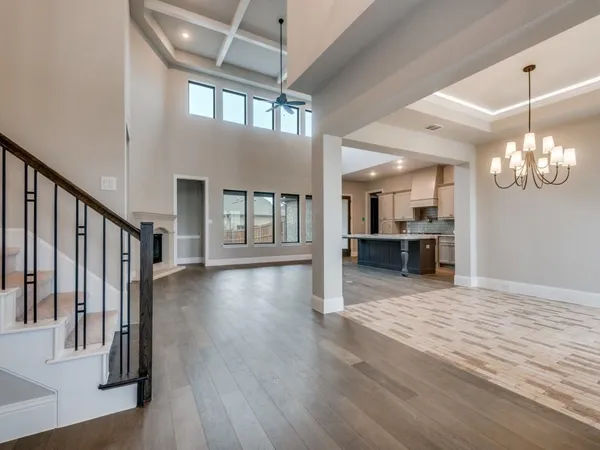 a view of a livingroom with wooden floor and a kitchen space
