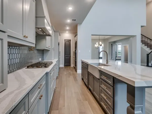 a large kitchen with stainless steel appliances granite countertop a lot of counter space and wooden floor