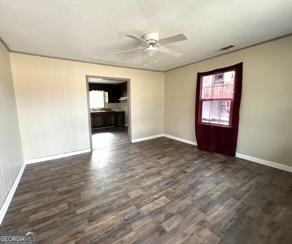a view of a livingroom with wooden floor and a ceiling fan