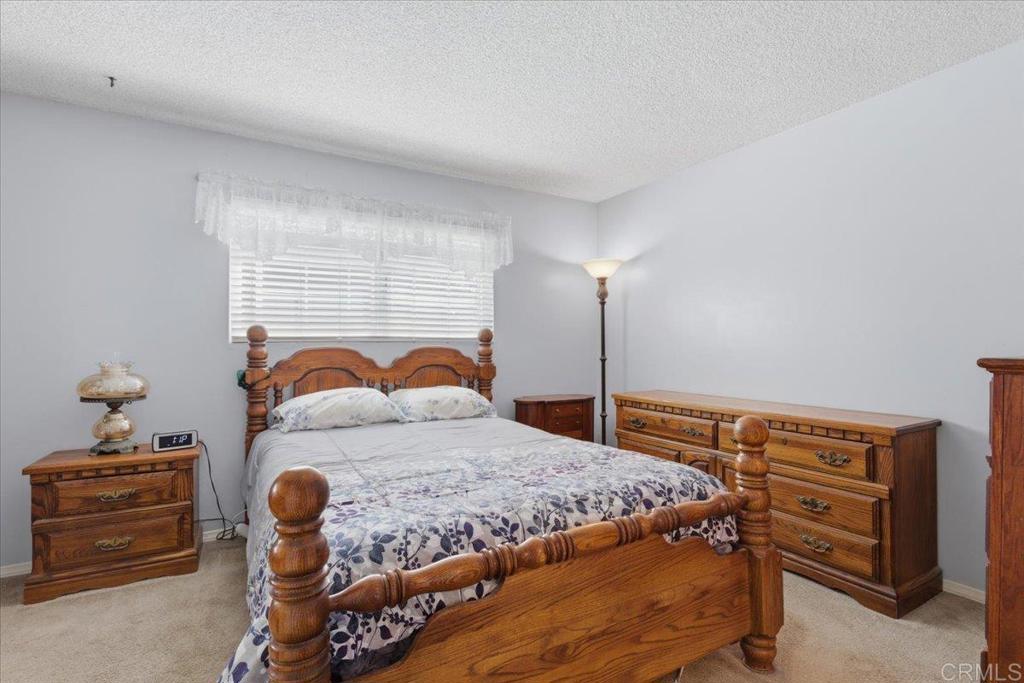 8773 Leigh Avenue Spring Valley, CA 91977 - Photo 20 of 30 a bedroom with a bed and a chandelier