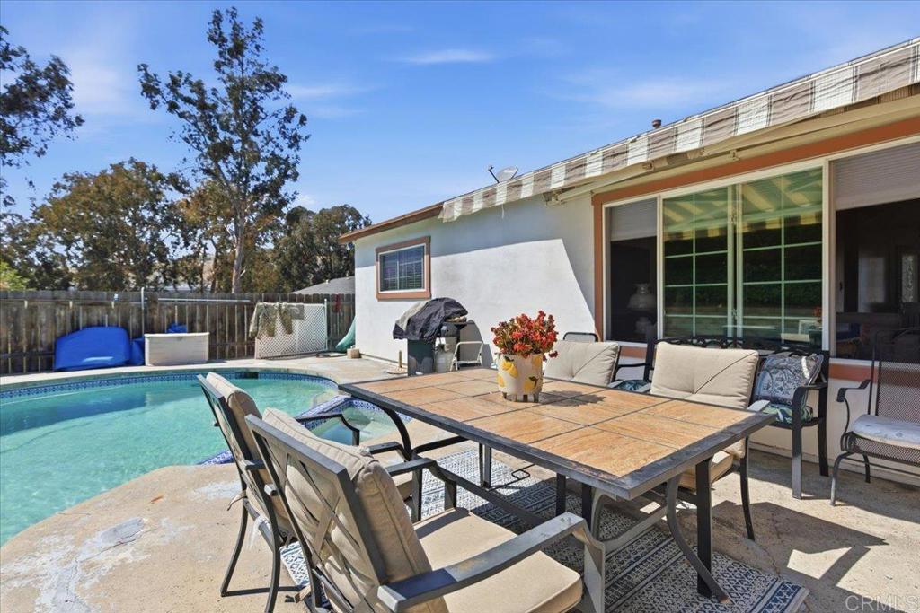 8773 Leigh Avenue Spring Valley, CA 91977 - Photo 25 of 30 a view of a patio with table and chairs with wooden floor and fence