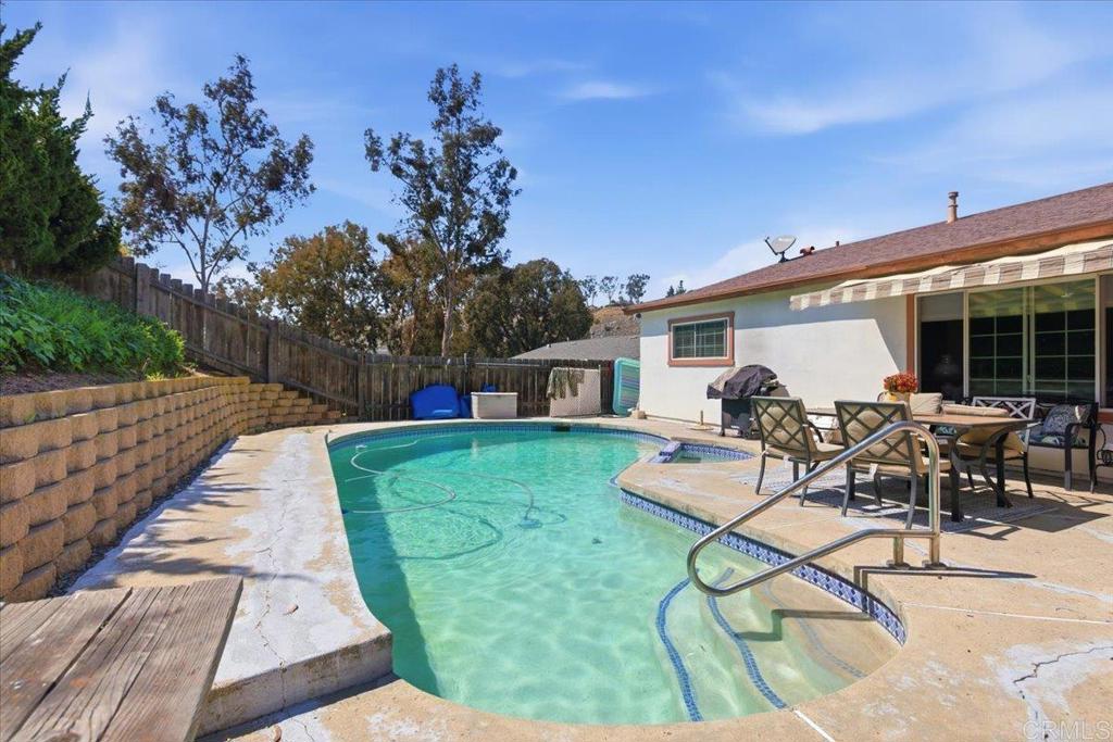 8773 Leigh Avenue Spring Valley, CA 91977 - Photo 26 of 30 a view of a patio with table and chairs potted plants with wooden fence