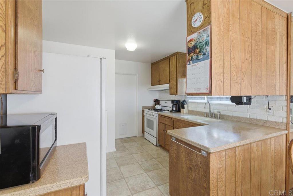 8773 Leigh Avenue Spring Valley, CA 91977 - Photo 6 of 30 a kitchen with a sink a stove and a refrigerator