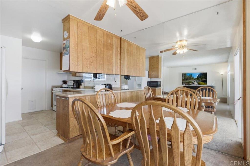 8773 Leigh Avenue Spring Valley, CA 91977 - Photo 9 of 30 a very nice looking dining room with furniture a chandelier fan and a kitchen view