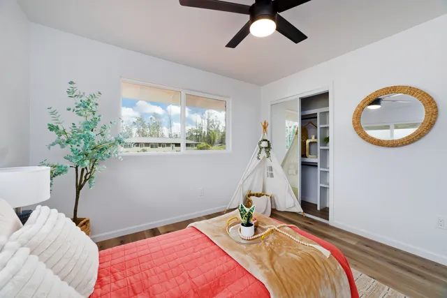 a bedroom with a bed and a potted plant