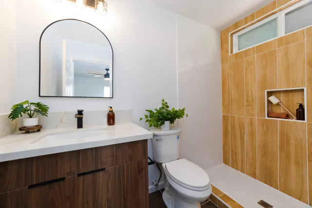 a bathroom with a toilet a sink and mirror