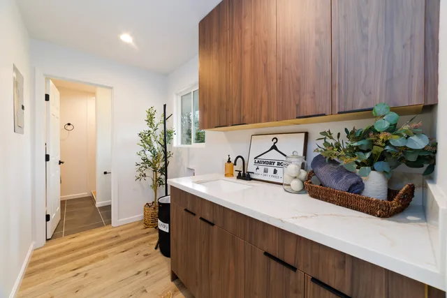 a kitchen with a sink a potted plant and cabinets