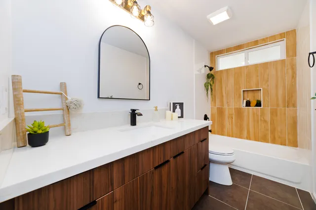 a bathroom with a sink a toilet and shower