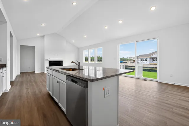 a kitchen with kitchen island granite countertop a sink and wooden cabinets
