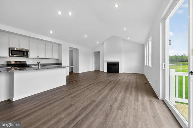 a view of kitchen with granite countertop stainless steel appliances refrigerator sink and cabinets