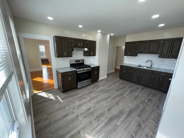 a large kitchen with stainless steel appliances a sink and a refrigerator