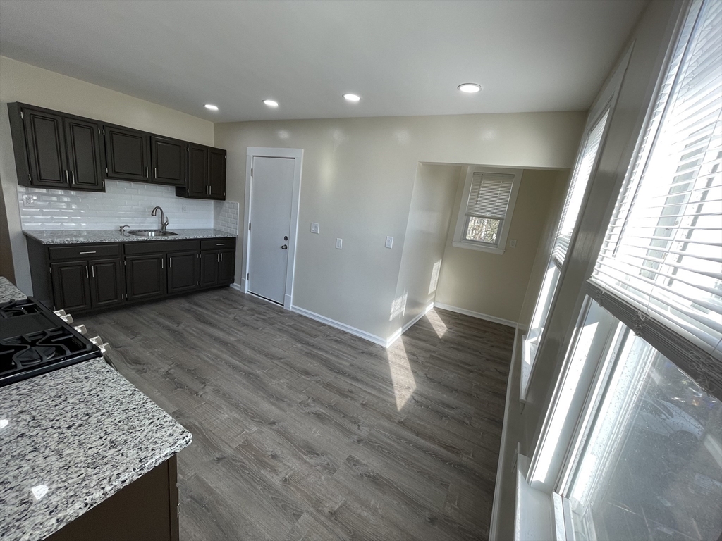 480 Harvard Street, Unit 3 Boston, MA 02124 - Photo 2 of 4 a kitchen with stainless steel appliances granite countertop a sink stove and refrigerator