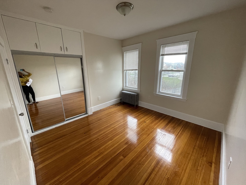 480 Harvard Street, Unit 3 Boston, MA 02124 - Photo 3 of 4 a view of empty room with wooden floor and fan