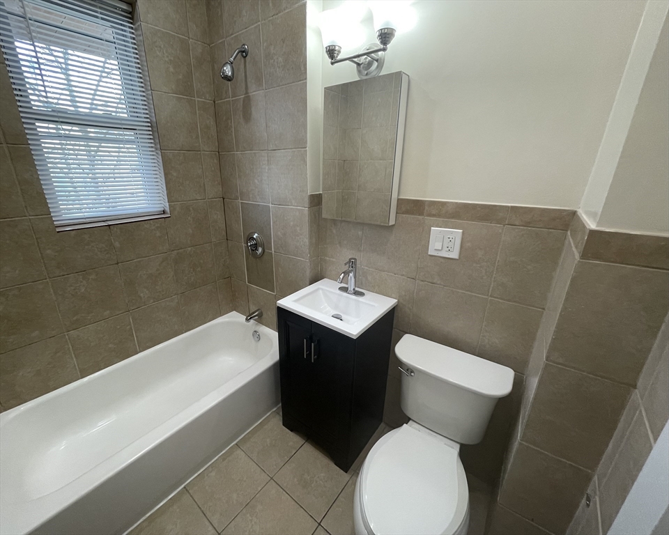 480 Harvard Street, Unit 3 Boston, MA 02124 - Photo 4 of 4 a white toilet sitting next to a bath tub