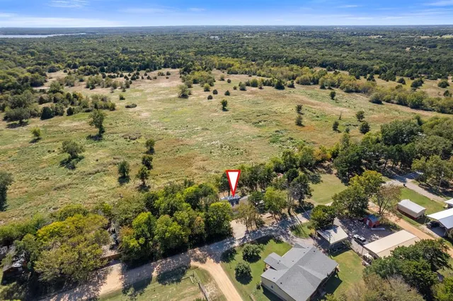 an aerial view of residential houses with outdoor space and trees