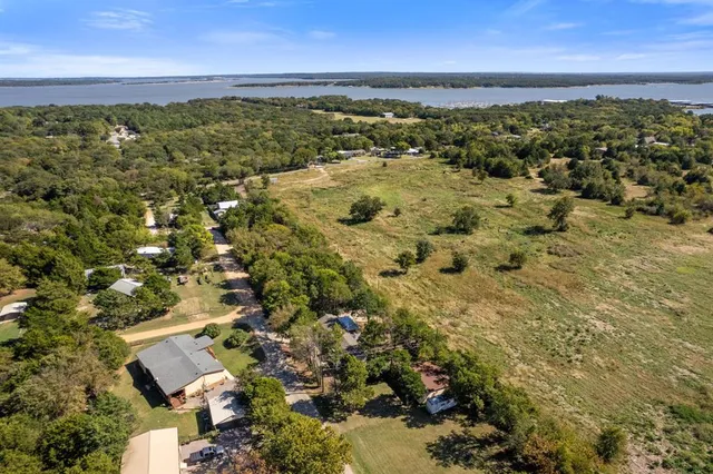 an aerial view of residential house with outdoor space and trees all around