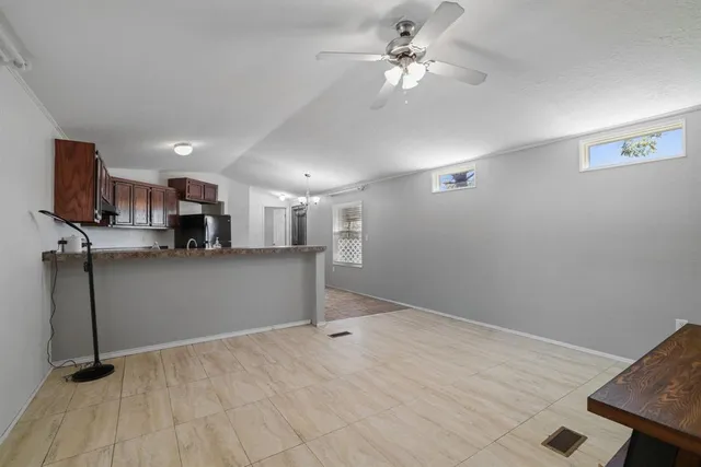 a view of kitchen and empty room with wooden floor