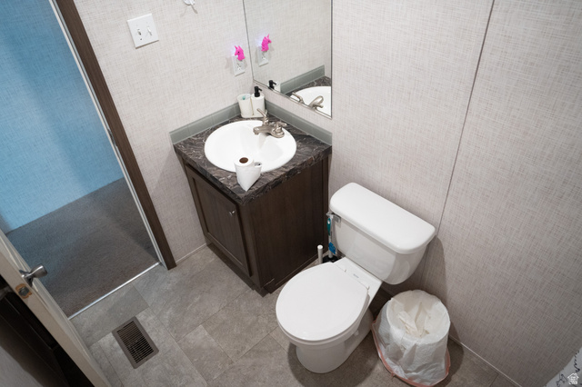 2491 Highway 89, Unit 111 Pleasant View, UT 84404 - Photo 16 of 20 Half bath featuring vanity, wallpapered walls, and light tile patterned floors