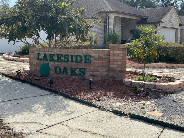 a view of a house with a yard and potted plants