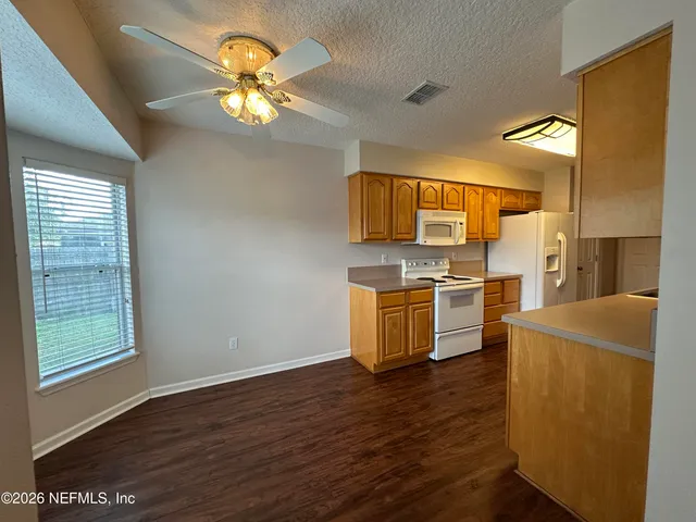 a kitchen with stainless steel appliances a stove a refrigerator a sink a microwave oven with wooden floor