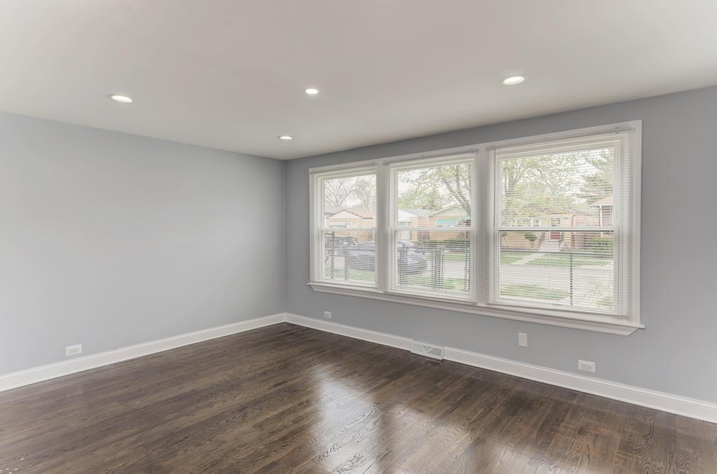 1411 West 114th Place Chicago, IL 60643 - Photo 4 of 25 an empty room with wooden floor and windows