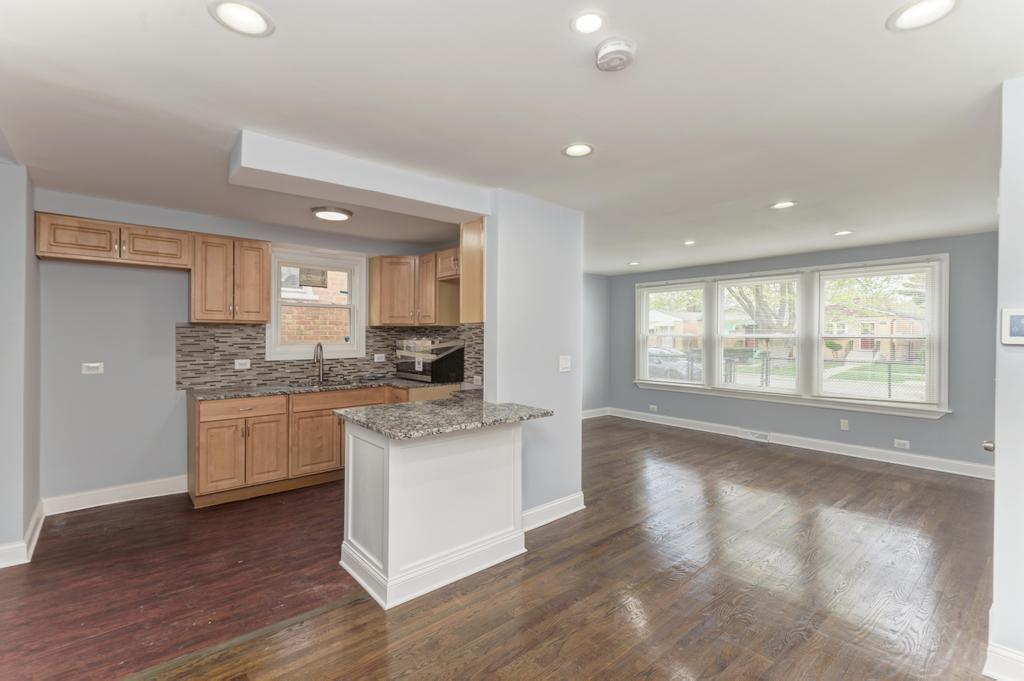 1411 West 114th Place Chicago, IL 60643 - Photo 8 of 25 a kitchen with granite countertop white cabinets and wooden floor