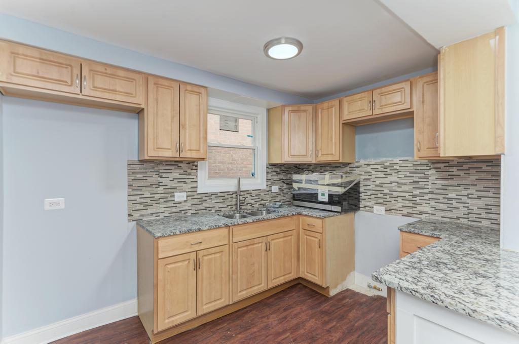 1411 West 114th Place Chicago, IL 60643 - Photo 9 of 25 a kitchen with stainless steel appliances granite countertop a stove a sink and white cabinets
