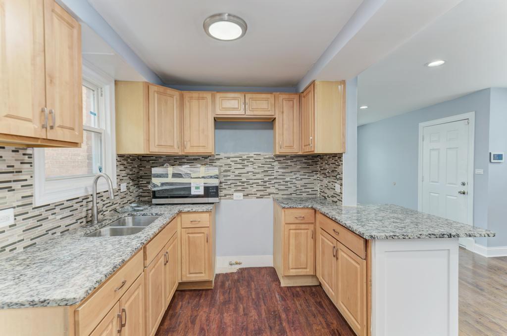 1411 West 114th Place Chicago, IL 60643 - Photo 10 of 25 a kitchen with stainless steel appliances granite countertop a sink stove and cabinets