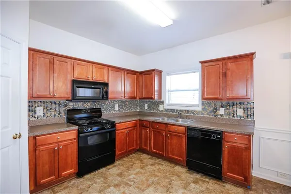 a kitchen with stainless steel appliances granite countertop a stove sink microwave and refrigerator