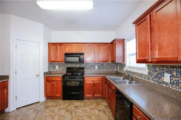 a kitchen with stainless steel appliances granite countertop a stove a sink and a microwave