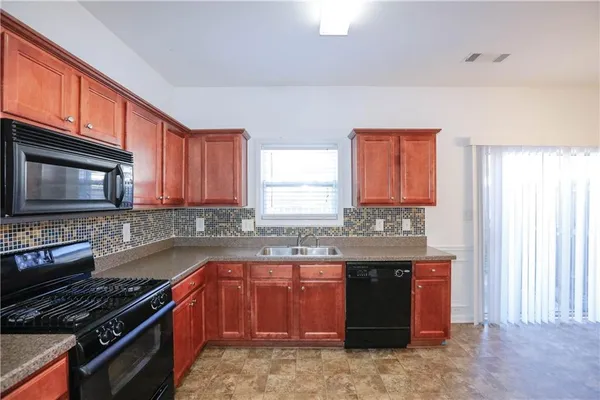 a kitchen with stainless steel appliances granite countertop a stove sink and cabinets