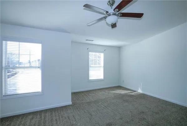an empty room with a window and a fan
