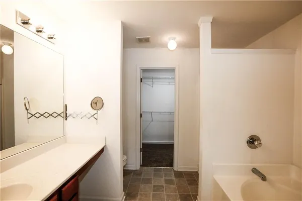 a bathroom with a tub sink and shower