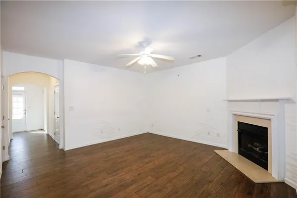 a view of a room with a ceiling fan and a fireplace