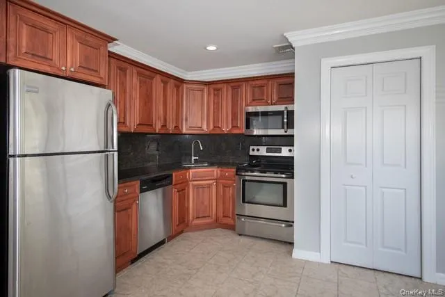 a kitchen with stainless steel appliances granite countertop a refrigerator and a stove top oven