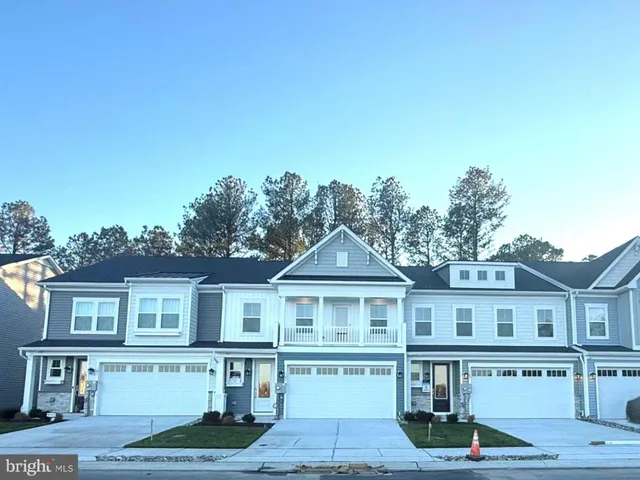 a front view of a house with yard and parking