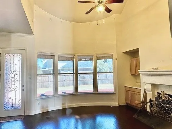 a living room with hardwood flooring and a ceiling fan
