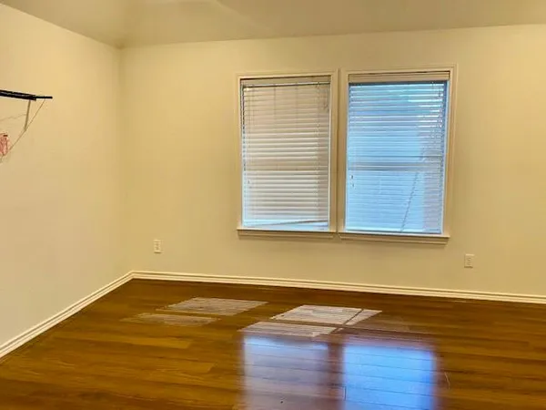 a room with wooden floor and a window