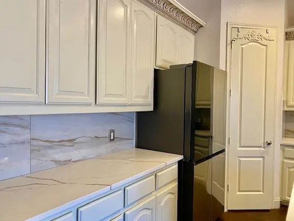 a kitchen with a refrigerator and cabinets
