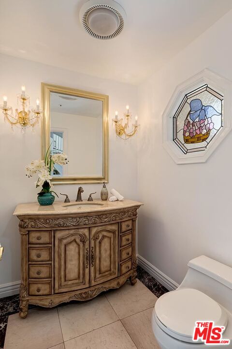 138 North Carson Road Beverly Hills, CA 90211 - Photo 5 of 22 a bathroom with a toilet a sink and mirror