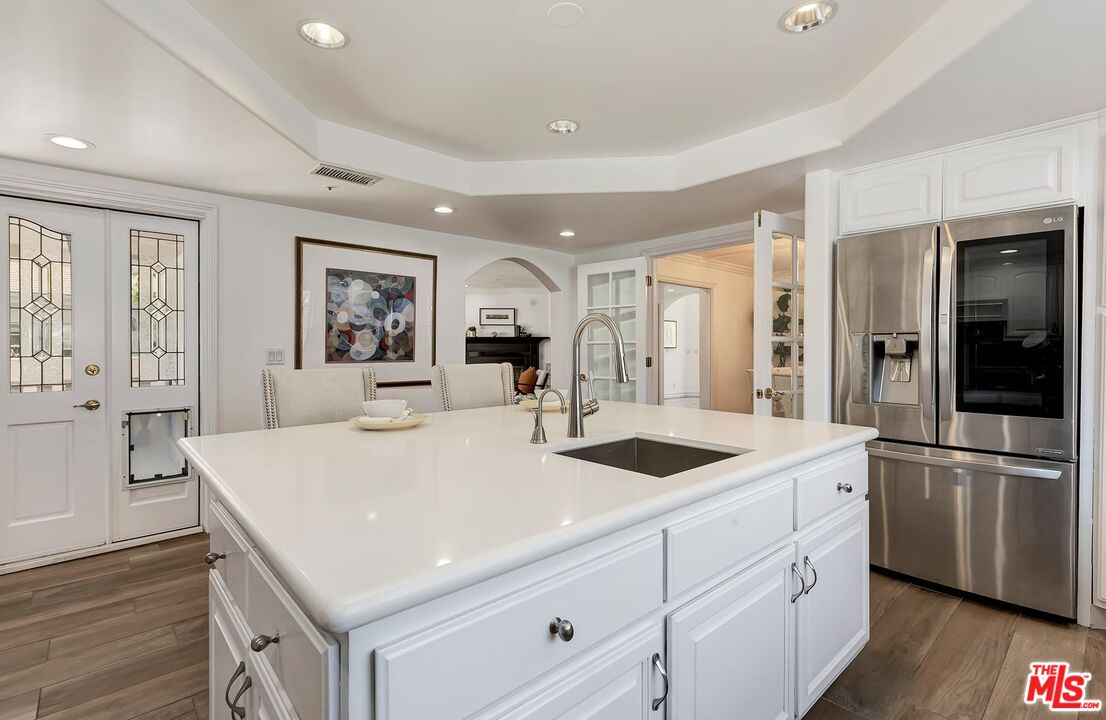 138 North Carson Road Beverly Hills, CA 90211 - Photo 10 of 22 a kitchen with stainless steel appliances granite countertop a sink and dishwasher with wooden floor