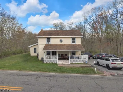 a front view of a house with a garden and trees